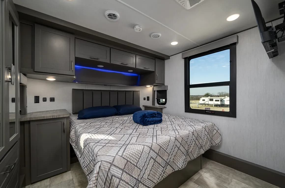 RV bedroom with a made king-size bed